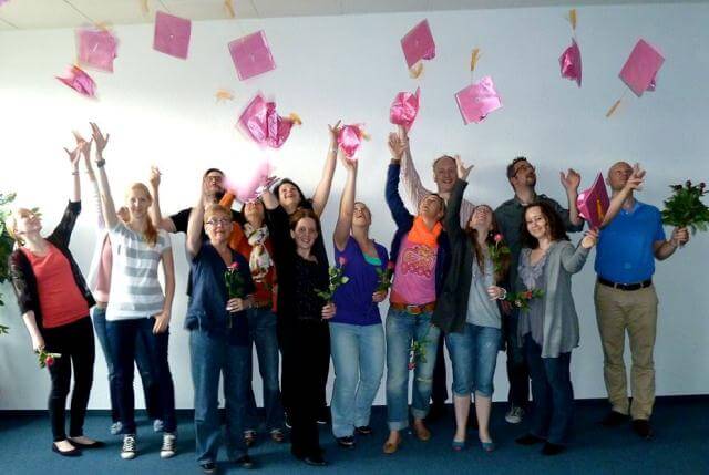 Die Teilnehmer der Fortbildung zum Online Marketing Manager (IHK) werfen ihre pinken Doktorhüte in die Luft